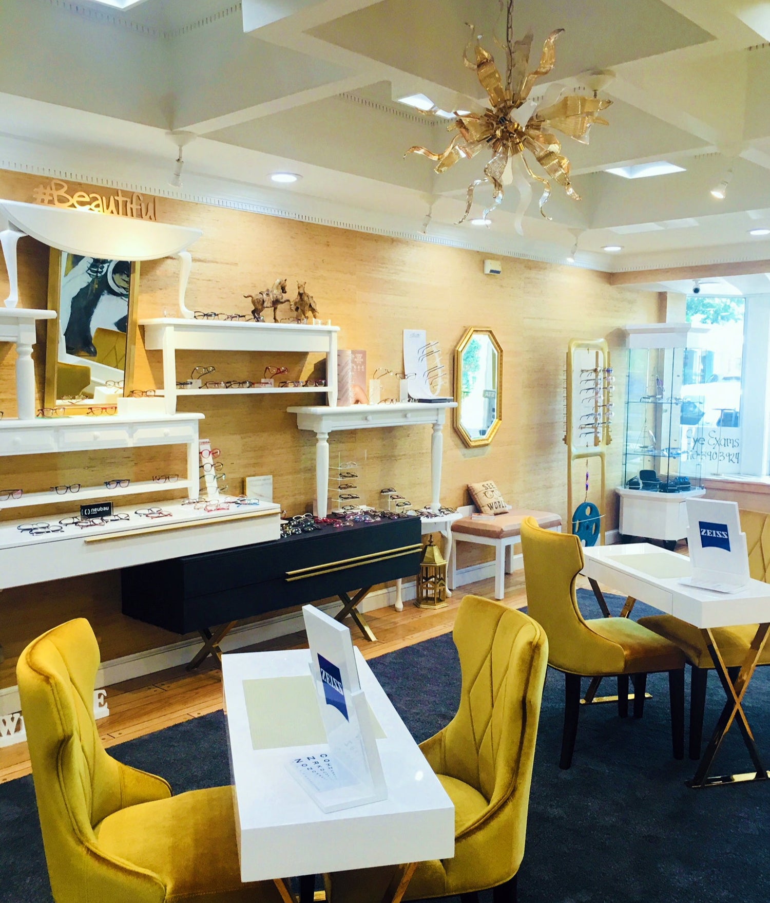 Modern interior design with yellow chairs, white tables, and a chandelier.