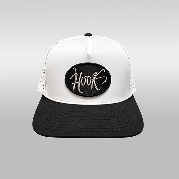 A black and white trucker hat with a white front panel, black brim, and a black oval patch on the front featuring the word 'Hook' in white script.